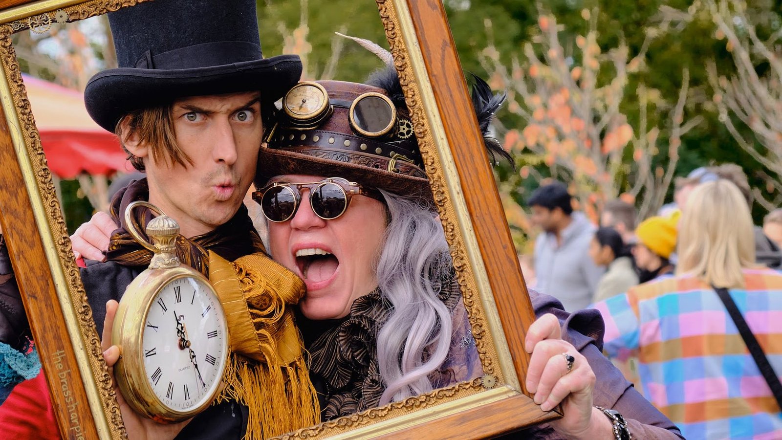 Costumed festival performers posing with a decorative frame